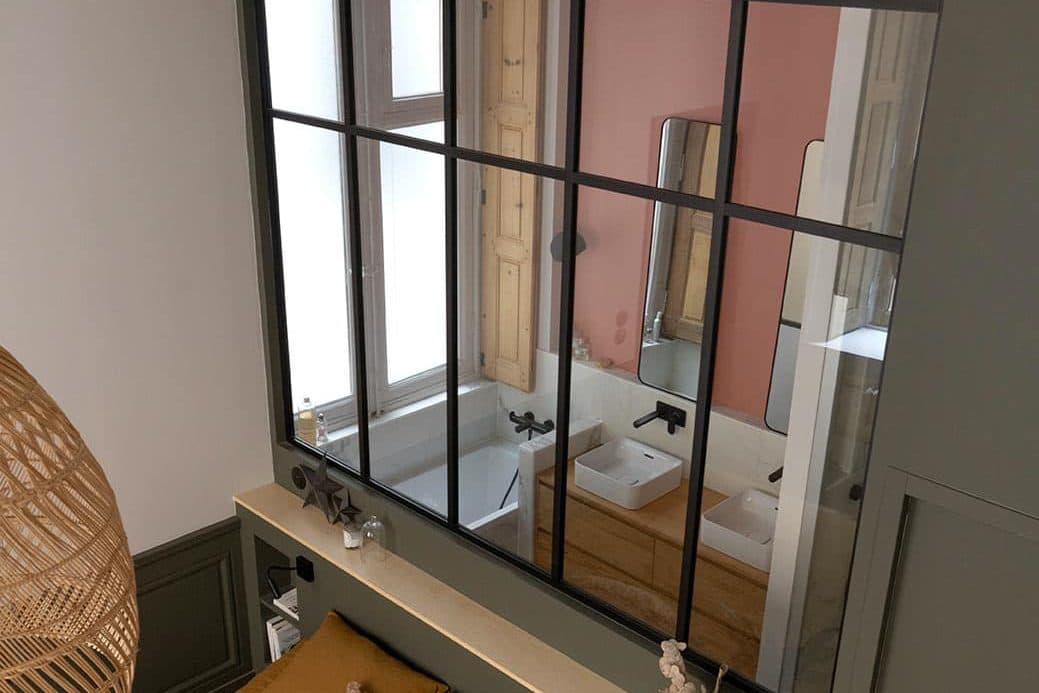 Salle de bain aperçue à travers la verrière d’atelier