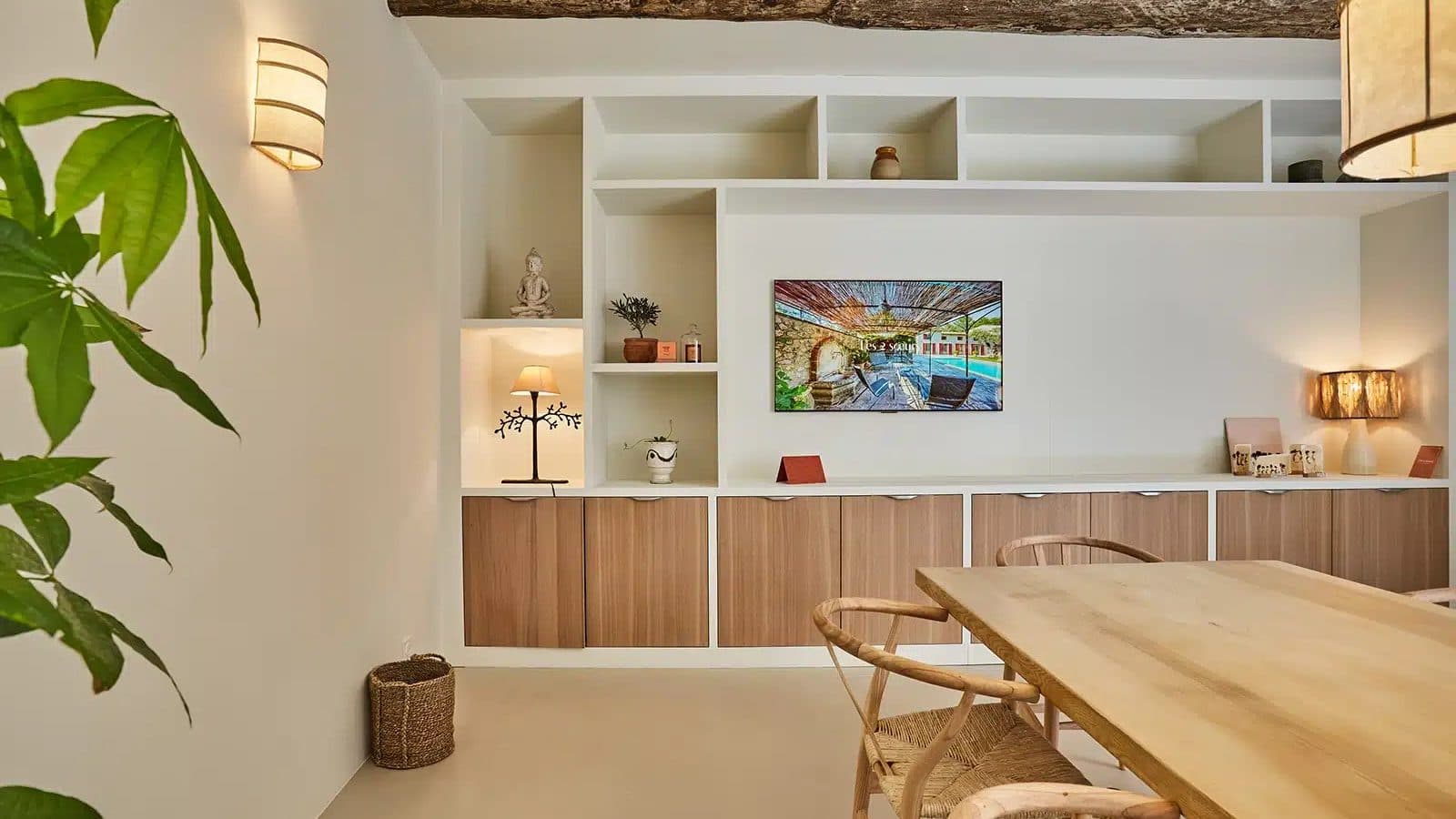 Espace d'accueil de l'agence avec poutres apparentes et béton ciré teinte lin