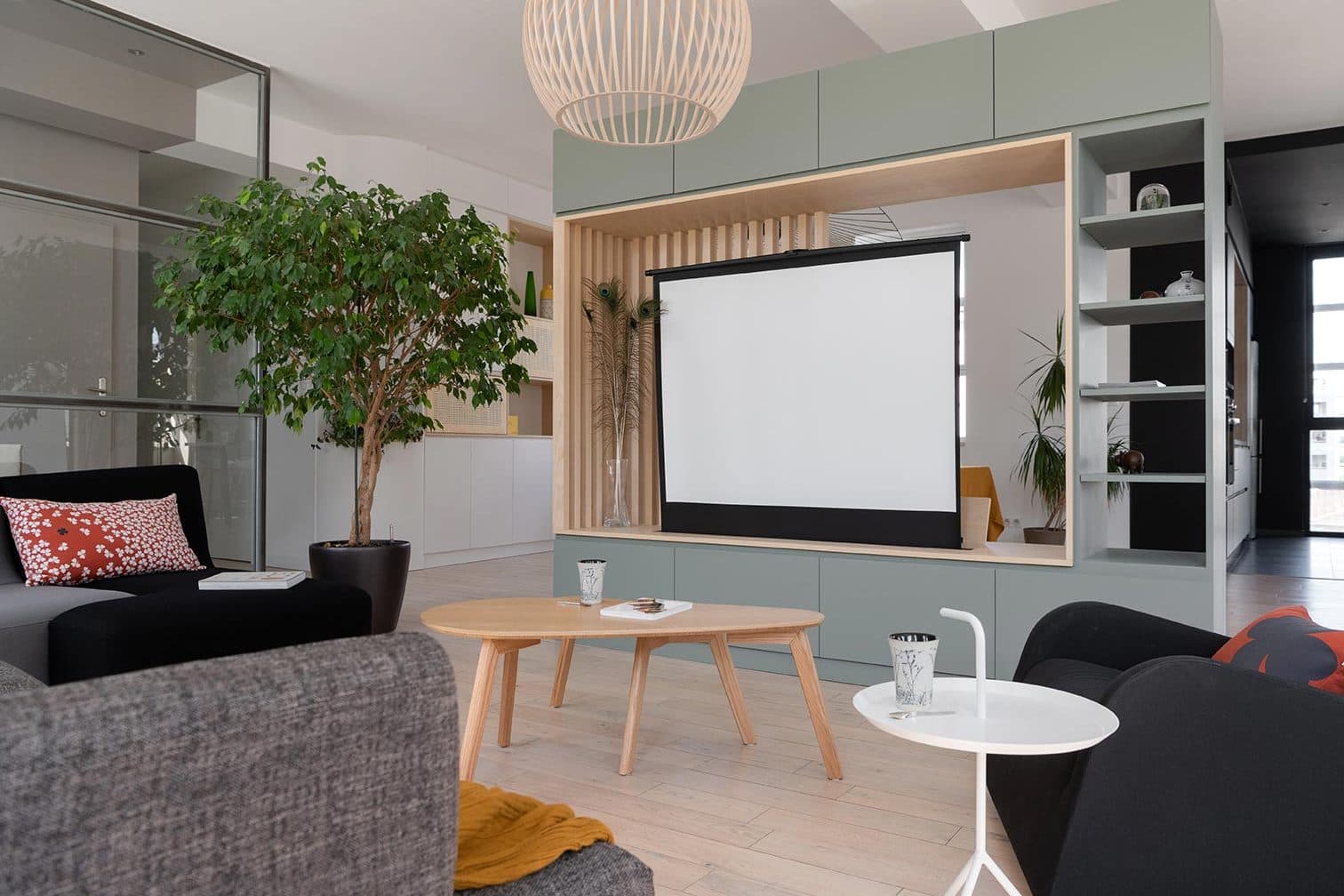 Salon avec écran de projection encastré dans le module de rangement