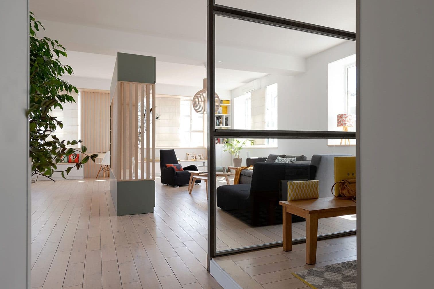 Verrière d’atelier noire entre le couloir et la pièce à vivre