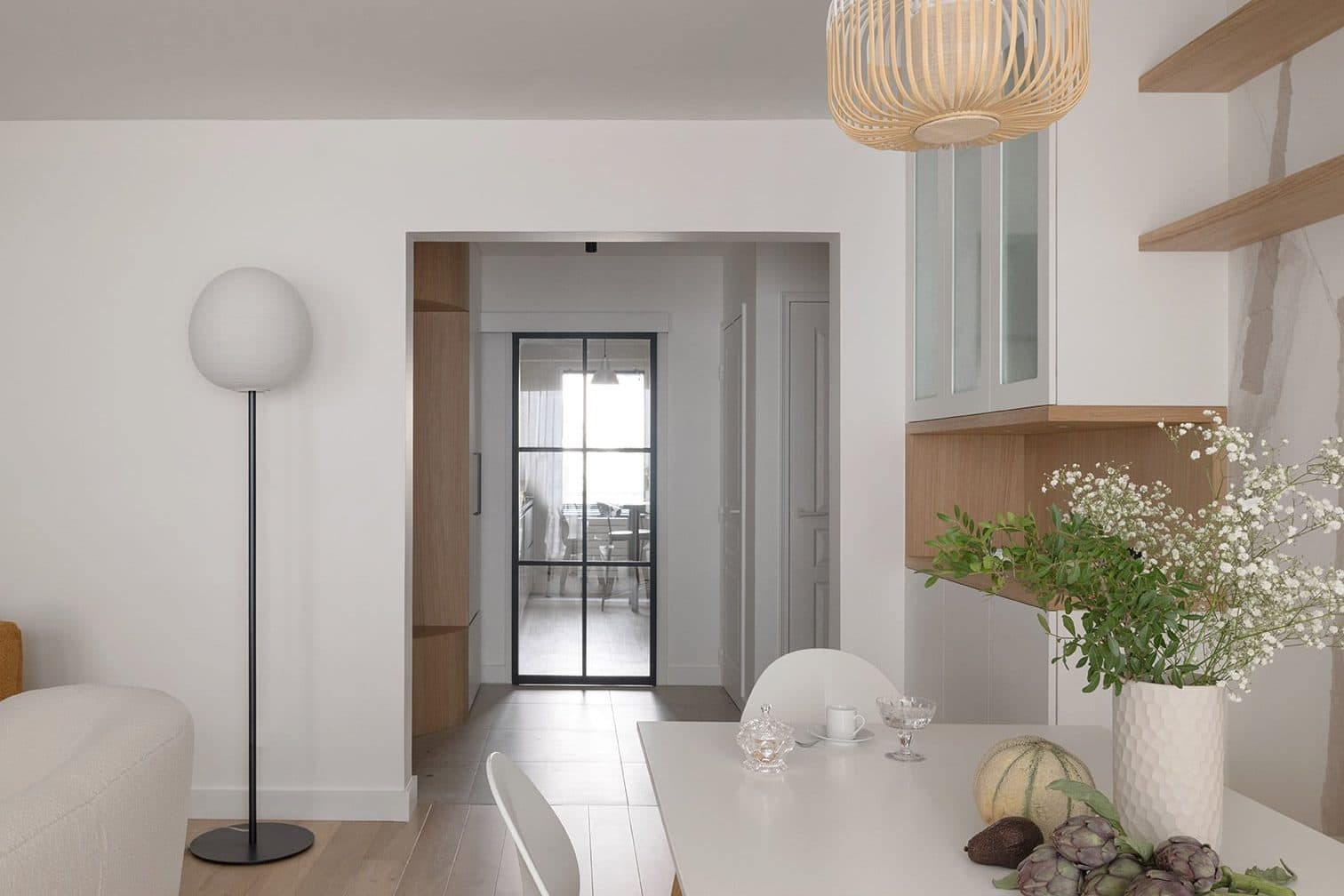 Entrée avec lampadaire et porte vitrée vers la pièce de vie
