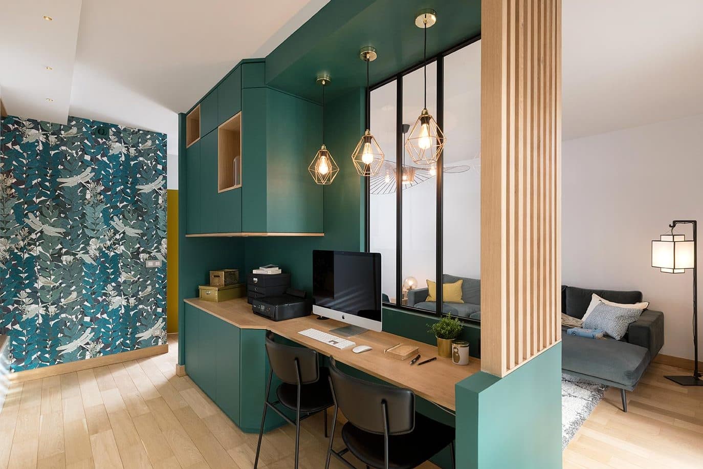 Bureau intégré dans la paroi verte, derrière la verrière d’atelier