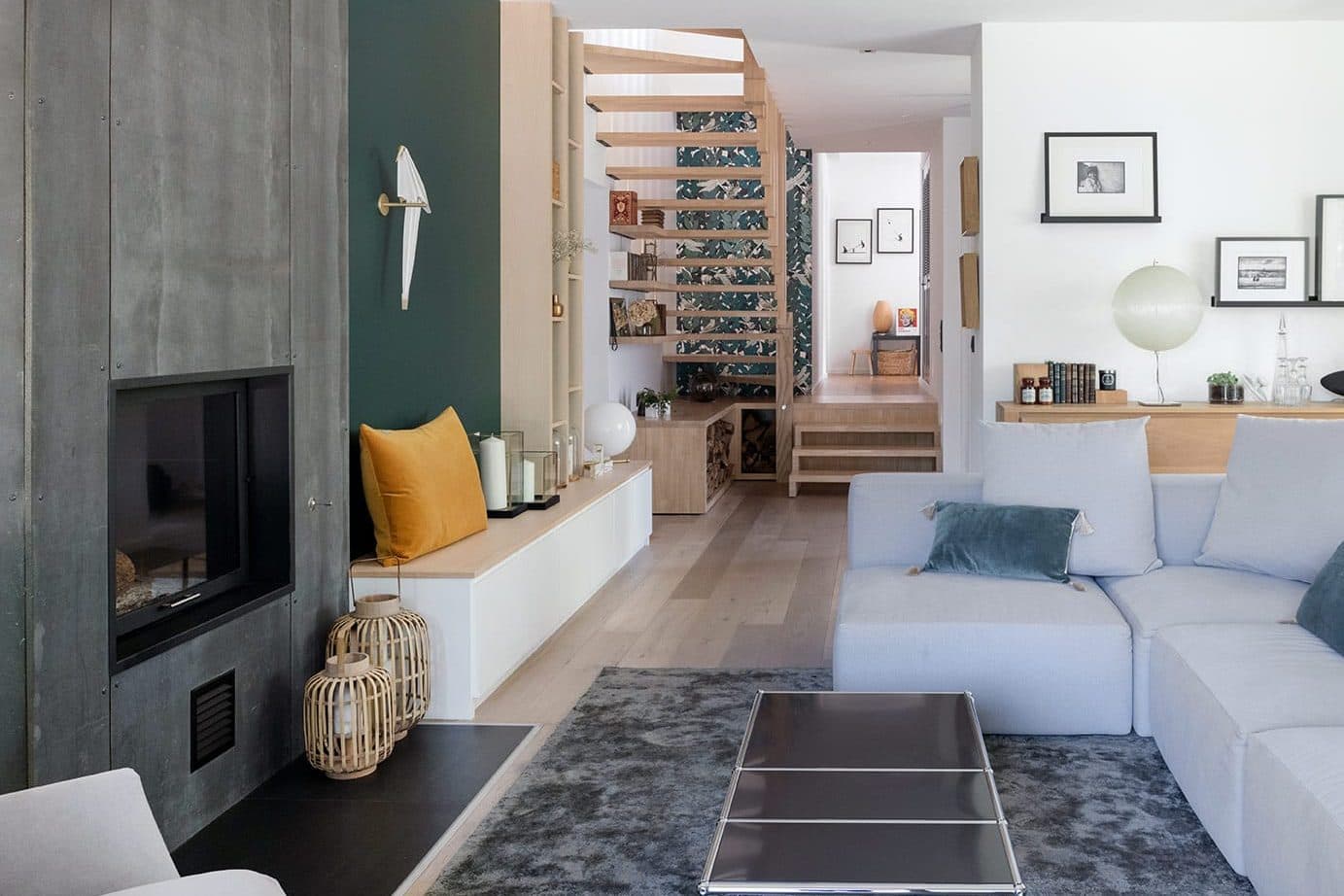 Salon avec cheminée, mur vert profond et rangements sur mesure