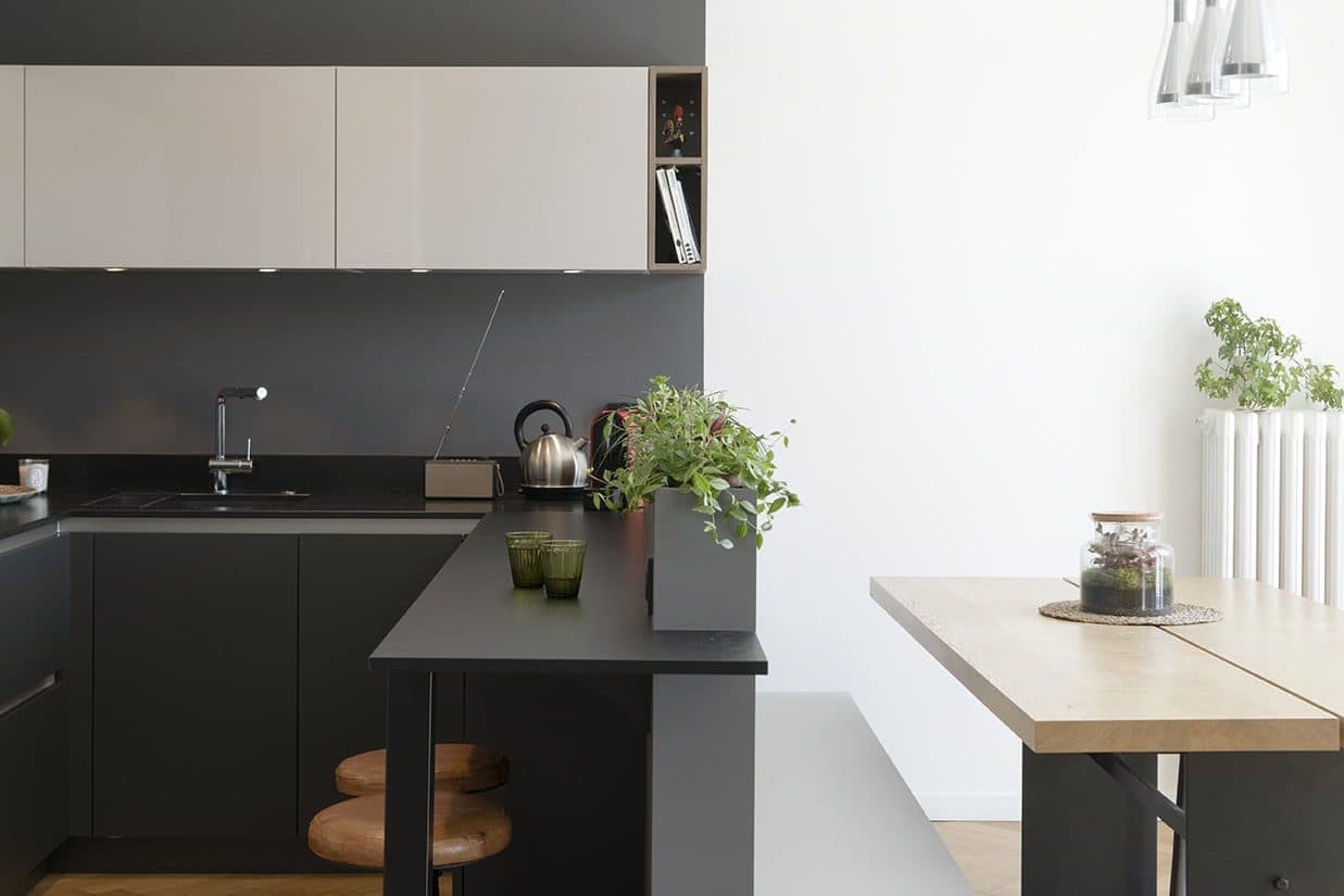 Cuisine noire ouverte sur la pièce à vivre