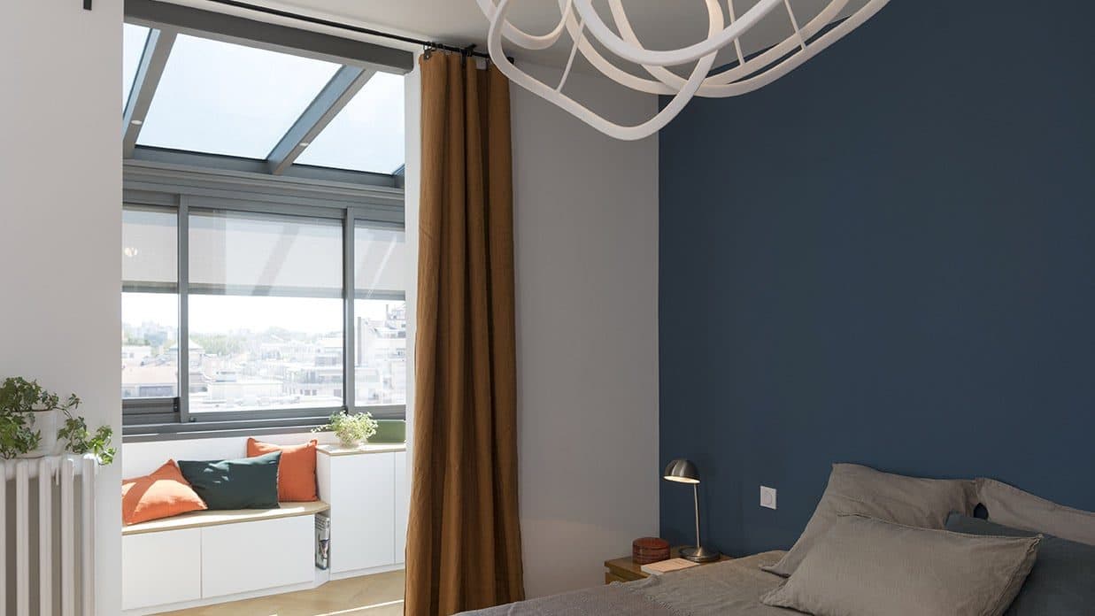 Chambre au mur bleu profond et banquette sous la fenêtre