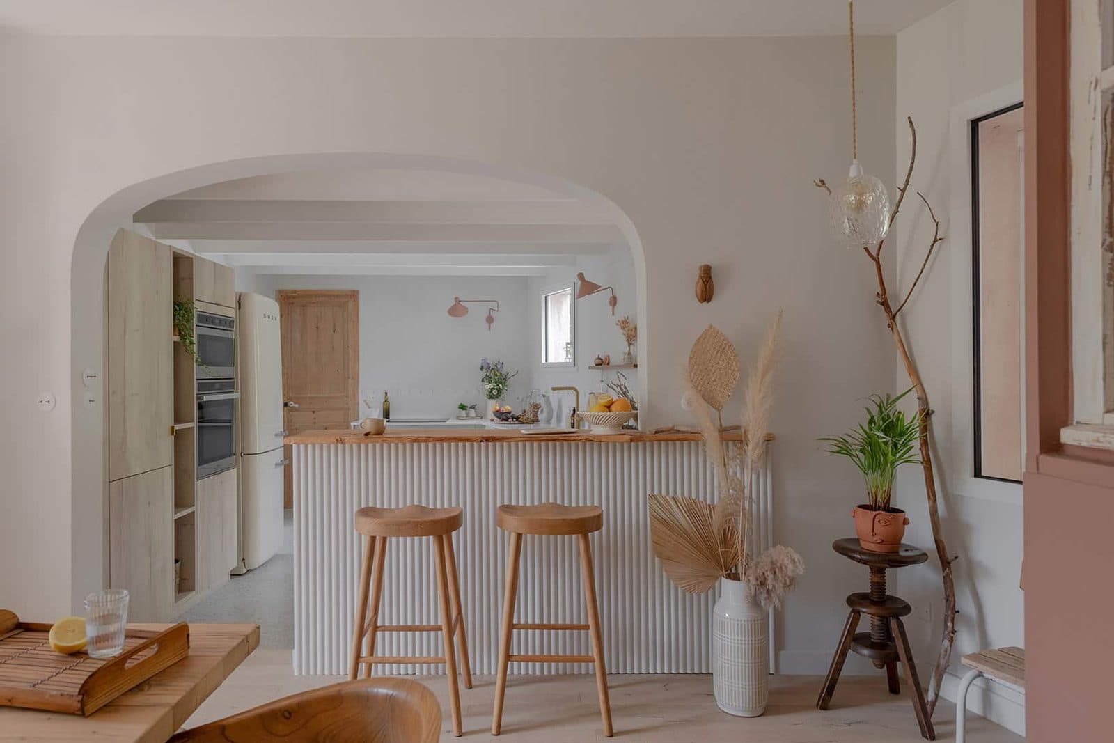 Cuisine avec îlot et tabourets sous une arche